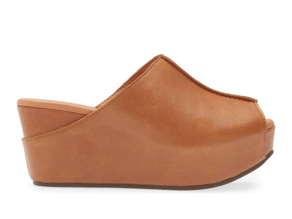 Cognac leather slide in peep toe wedge platform shoe with exposed seam on upper design on a white background side view