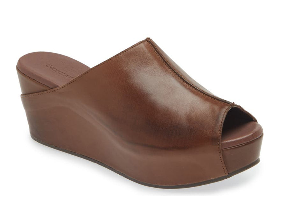 Dark brown leather slide in peep toe wedge platform shoe with exposed seam on upper design on a white background side angle view