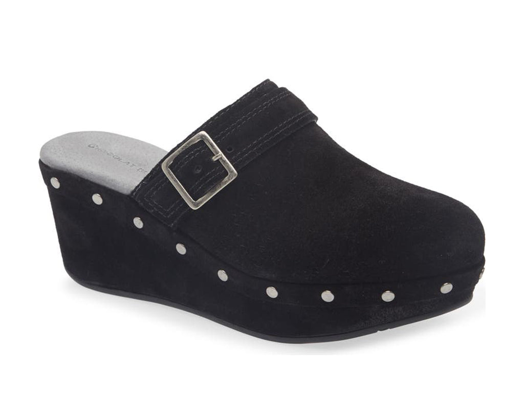 Black suede slide in clog wedge platform shoe with top strap and buckle decoration and grommet studs on a white background side angle view