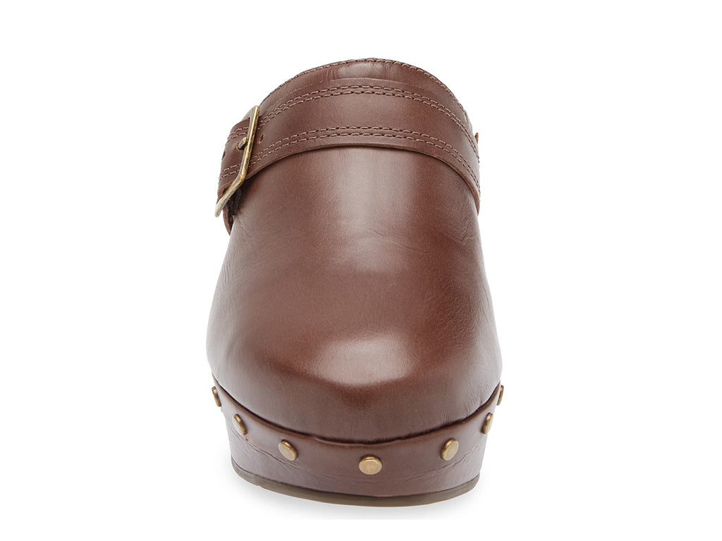 Brown leather slide in clog wedge platform shoe with top strap and buckle decoration and grommet studs on a white background front view