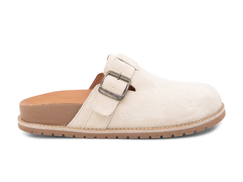 Beige slip-on shoe with a brown sole, strap and buckle on a white background side view