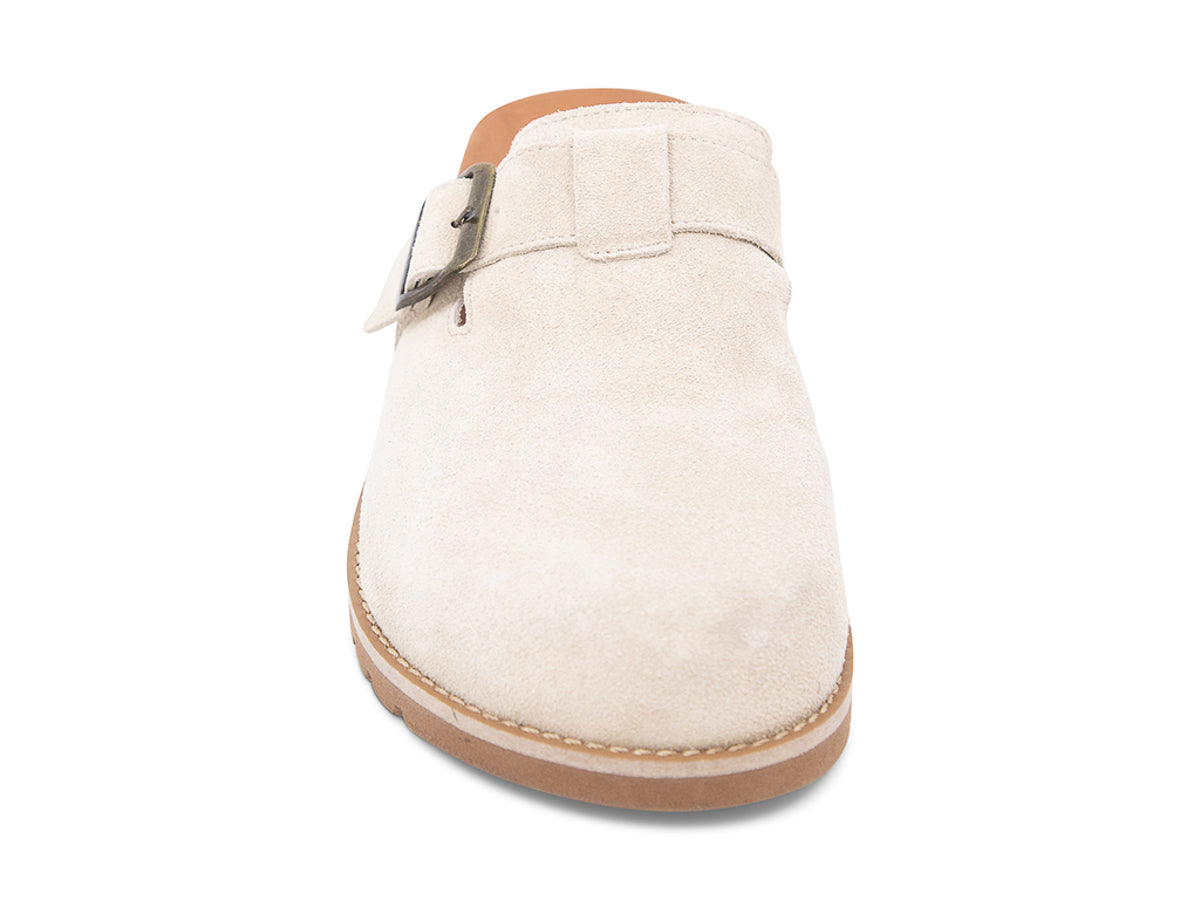 Beige slip-on shoe with a brown sole, strap and buckle on a white background front view