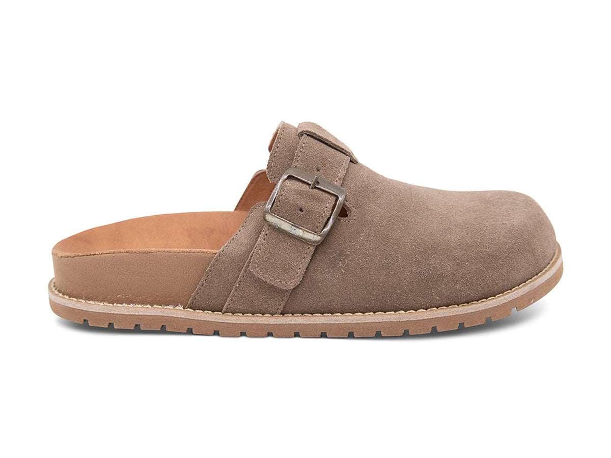 Brown slip-on shoe with a brown sole, strap and buckle on a white background side view