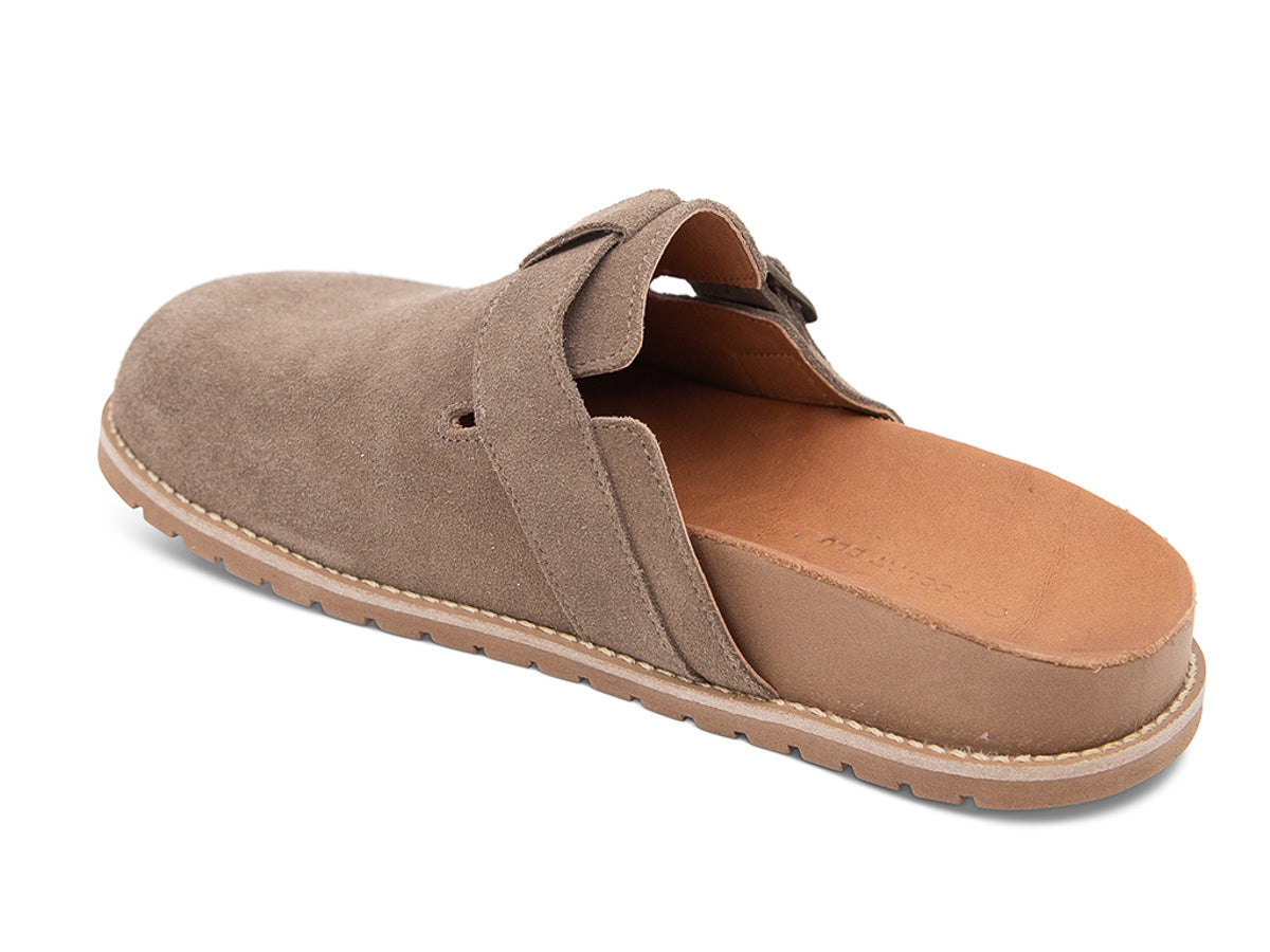 Brown slip-on shoe with a brown sole, strap and buckle on a white background side angle view
