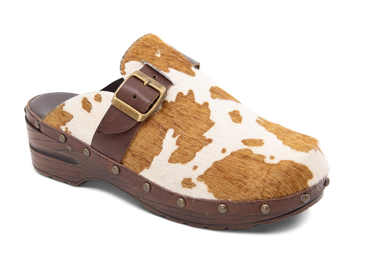 Calf hair clog with brown and white pattern, brown strap and gold buckle on a white background angled view