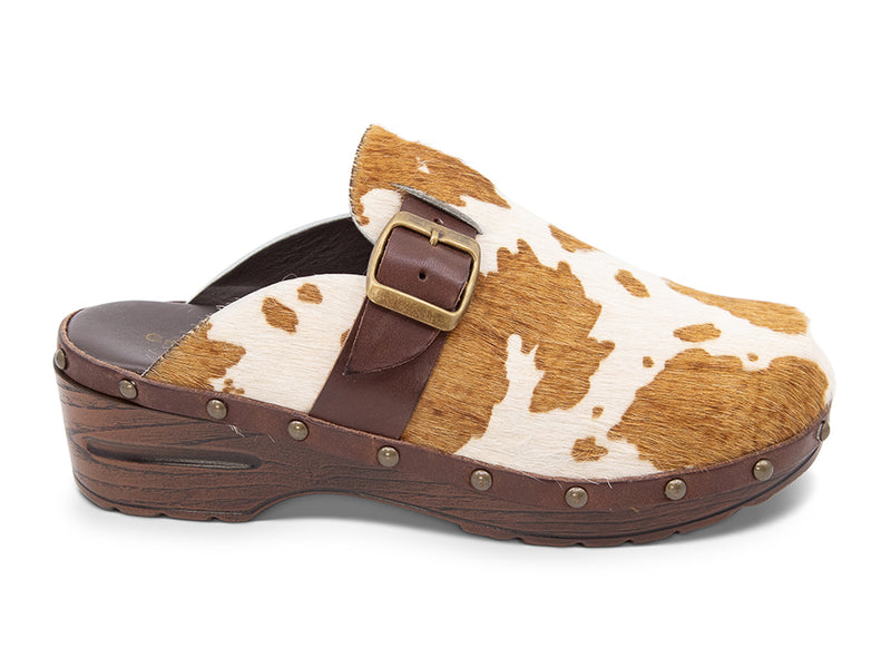 Calf hair clog with brown and white pattern, brown strap and gold buckle on a white background side view